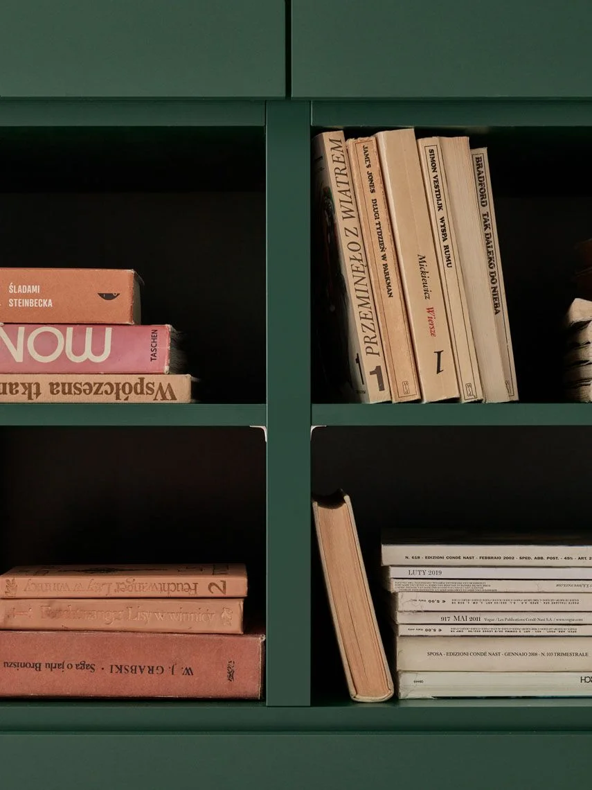 Zielona komoda z książkami i dodatkami w stylu vintage